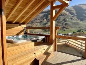 a wooden deck with a hot tub on a mountain at Chalet Neuf du Pape in Les Deux Alpes