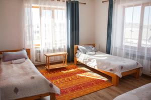 a room with two beds and a window at Guest House Altyn Oimok in Bokonbayevo