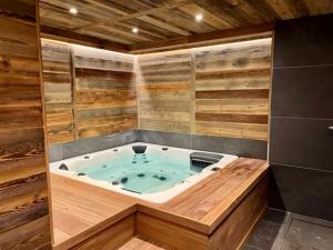 a jacuzzi tub in a room with wooden walls at Chalet Neuf du Pape in Les Deux Alpes