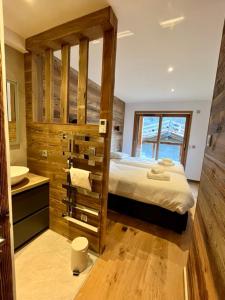 a bedroom with a bed and a bathroom with a sink at Chalet Neuf du Pape in Les Deux Alpes