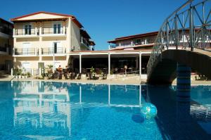 a swimming pool with a ball in the water next to a building at Majestic Hotel & Spa in Laganas