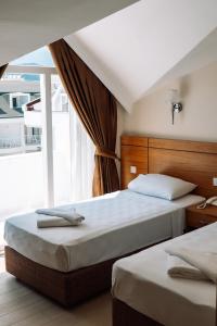 two beds in a room with a window at BESO BEACH HOTEL in Agva
