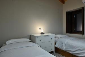 a bedroom with two beds and a dresser with a light on it at PALIO HANI in Konitsa