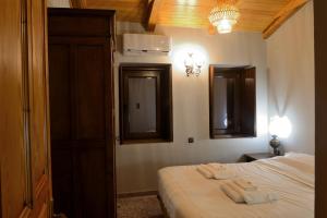 1 dormitorio con 1 cama con 2 toallas en PALIO HANI en Konitsa