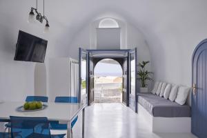 un soggiorno con tavolo e divano di Fava Eco Suites a Oia