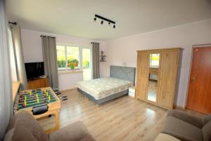 Una sala de estar con una cama y una mesa con un tablero de ajedrez. en Kosciuszko Apartment, en Muszyna