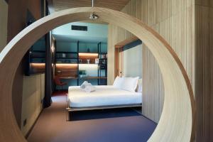 Schlafzimmer mit einem Bett und einem runden Spiegel in der Unterkunft 21 House of Stories Navigli in Mailand