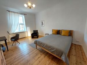 a bedroom with a bed and a desk and a window at Dainas 2-room Apartment - Arena Riga in Rīga