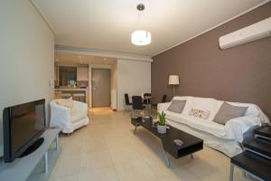 a living room with a white couch and a tv at Lovely New Βuild Flat Near Metro - Free Parking in Athens