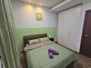 een slaapkamer met een bed met een paars kussen erop bij A.Foo Homestay 4.2 @ Vivacity Megamall Jazz Suite 4 in Kuching