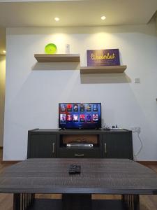 een woonkamer met een tv en een tafel bij A.Foo Homestay 4.2 @ Vivacity Megamall Jazz Suite 4 in Kuching
