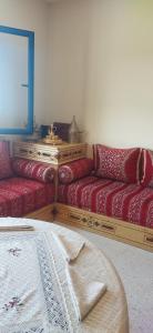 a living room with two red couches and a television at Lovers & Surfers Room - 5 min To Beach in Essaouira