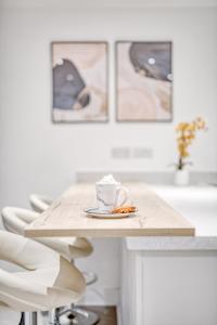una mesa con una taza de café en un plato en Columbia House, en Cheltenham