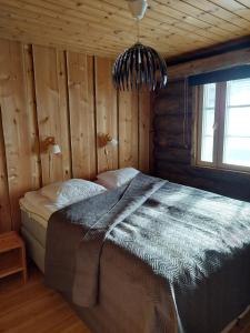 um quarto com uma cama num chalé de madeira em Lomaruka em Ruka