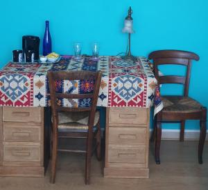 a table with two chairs and a table with a quilt on it at Bienvenue chez Lilaroma in Mérignac