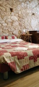 Bett in einem Zimmer mit einer Steinmauer in der Unterkunft B&B Nonno Severino in Santo Stefano di Sessanio