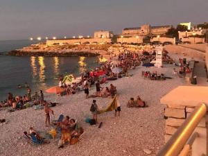 a crowd of people on a beach at night at Villa swamy in Bisceglie