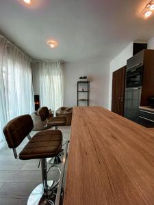 - un salon avec une table et des chaises en bois dans l'établissement Syrah Wellness Apartman Siófok, à Siófok