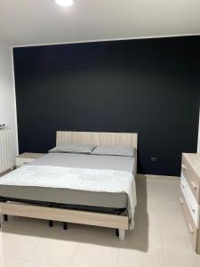 1 dormitorio con 1 cama grande y pared negra en Villa swamy, en Bisceglie