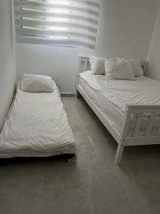 two beds in a room with white walls at מישל נופש ,צופית תחתית 6003 in Eilat