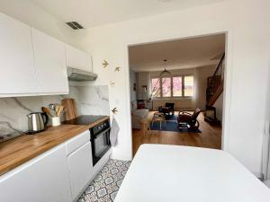 a kitchen with white cabinets and a living room at La chambre jaune maison avec grande terrasse et garage privé in Lille