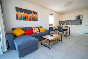 a living room with a blue couch and a table at Apartmani LE-LU in Kaštela