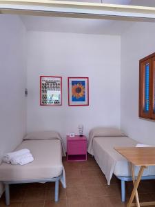 Habitación con 2 camas y mesa. en Appartamenti La Villa Peschici, en Peschici