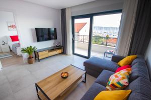 a living room with a blue couch and a table at Apartmani LE-LU in Kaštela