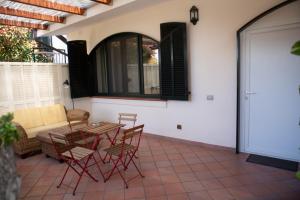 um pátio com uma mesa, cadeiras e um sofá em Villa Bianca em Castellammare di Stabia