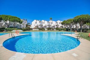 a swimming pool with blue water in a resort at MARIA DEL MAR SEA APARTMENT in Chiclana de la Frontera