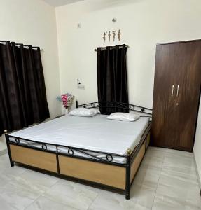 een groot bed in een kamer met zwarte gordijnen bij Elite stays in Pune