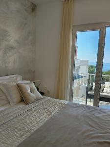 um quarto com uma cama e uma grande janela em Apartmani Leo-Marin em Makarska
