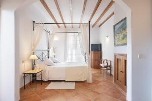 um quarto branco com uma cama e uma janela em Hotel Nord em Estellencs