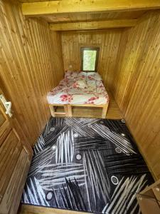 a small room with a bed in a wooden cabin at Cabana trei paltini in Poiana Vadului