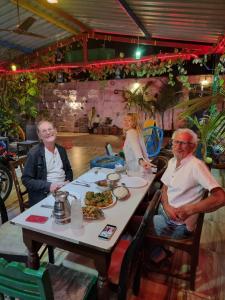 a group of people sitting at a table with food at Dream Vision Guest House in Diu