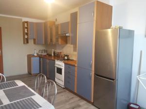 a kitchen with a stainless steel refrigerator and a table at Noclegi Janina Surmacz in Zwierzyniec