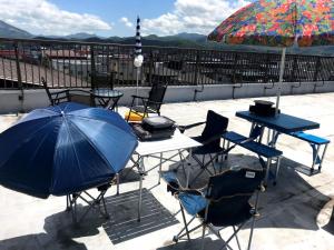 einen Tisch und Stühle mit Sonnenschirm auf einer Terrasse in der Unterkunft Big Stone Tsukuda 41平米 2F in Aomori