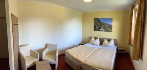 um quarto de hotel com uma cama e uma cadeira em Landhotel Gasthof Eichhof Natters em Innsbruck