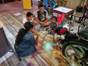 a group of people sitting on the floor playing with toy cars at Dream Vision Guest House in Diu
