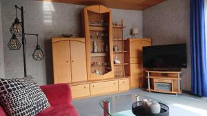 ein Wohnzimmer mit einem TV und Holzschränken in der Unterkunft Ferienwohnung Familie Boemer in Alf