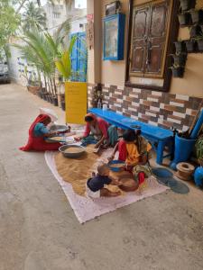 a group of people sitting on the floor eating food at Dream Vision Guest House in Diu