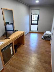 a room with a mirror and a desk with a television at J.Hill House in Seoul