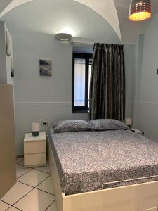 a bedroom with a bed and a window at Le stanze di Efesto in Linguaglossa