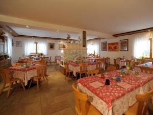 a dining room with tables and chairs in a room at Hotel Pensione Dolomiti in Falcade