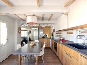 a kitchen with wooden cabinets and a table and chairs at Limanaki Villa in Lefkada