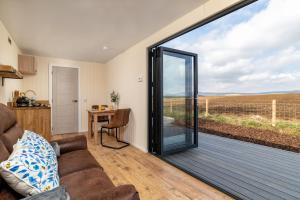 una sala de estar con una gran puerta corredera de cristal en Amazing Views Off Grid Cabin en Duncanston