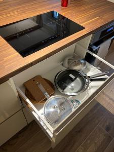 un cassetto della cucina con lavandino e padelle di LaLucia Luxury Suite Lake Como ad Argegno