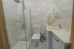 a bathroom with a shower and a toilet and a sink at Mc Palace Hotel Spa & Convention in Kyrenia
