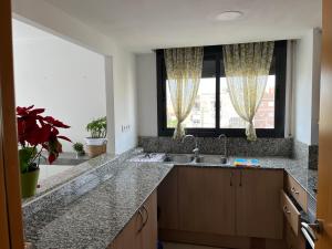 a kitchen with a sink and a window at Ático en Cubelles playa in Cubelles