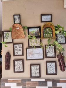 a wall with framed pictures on a wall at Dream Vision Guest House in Diu
